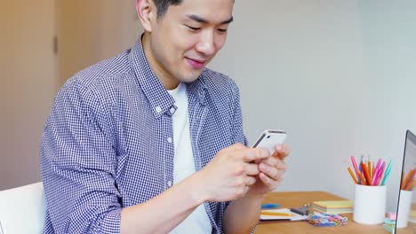 man using mobile phone at his desk