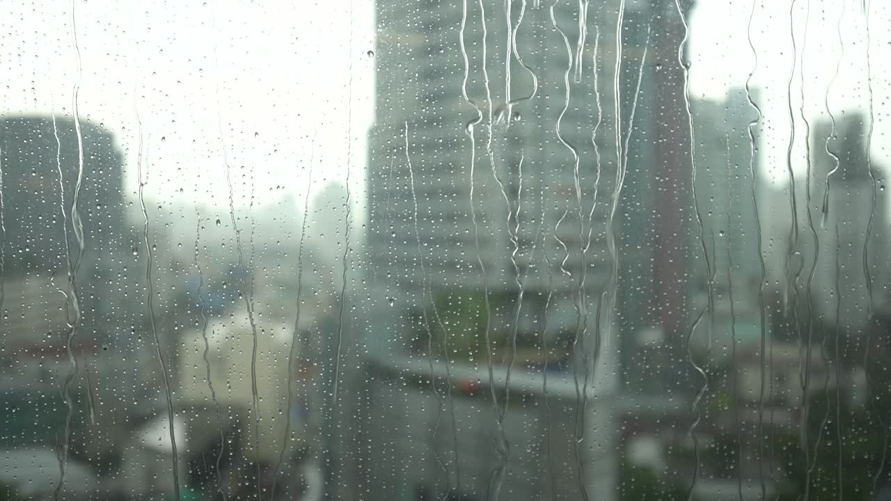 방에서 비가 내리면서 유리 창문에서 보이는 풍경.