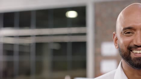 Half-portrait-of-happy-biracial-creative-businessman-smiling-in-office,-copy-space,-in-slow-motion