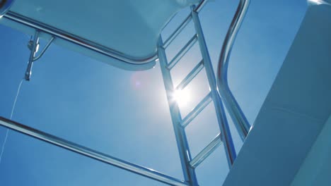 Sun-shining-behind-yacht-ladder,-low-angle-detail-shot