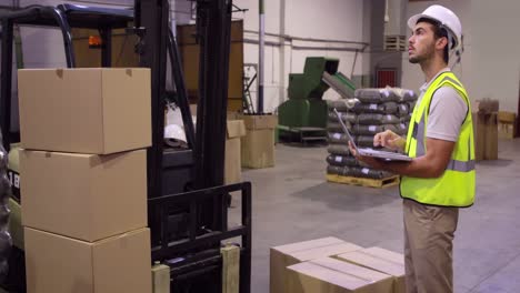Warehouse-worker-checking-cardboard-boxes-for-shipping
