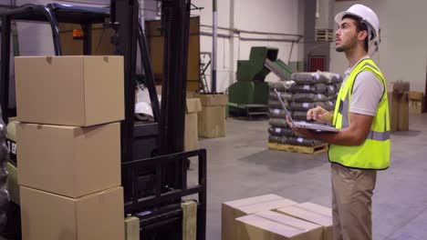 warehouse worker checking cardboard boxes for shipping