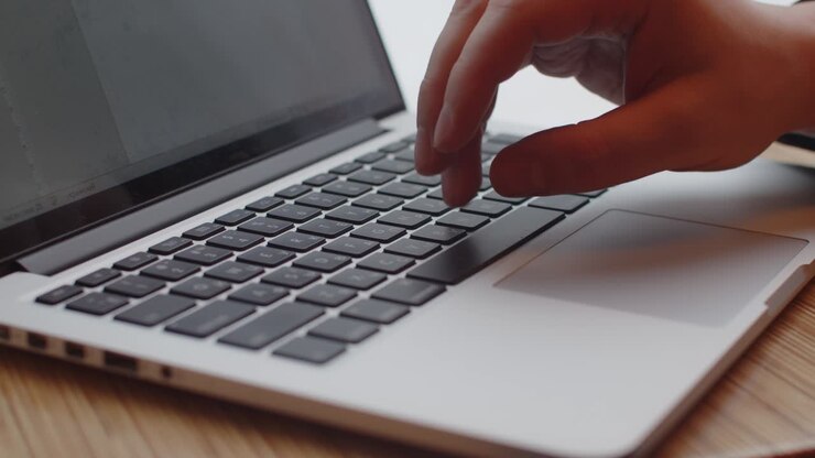 Nahaufnahme von Händen, die Text am Computer tippen. Online arbeiten.