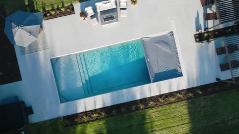 aerial and close-up views of a luxury backyard pool with retractable cover in motion