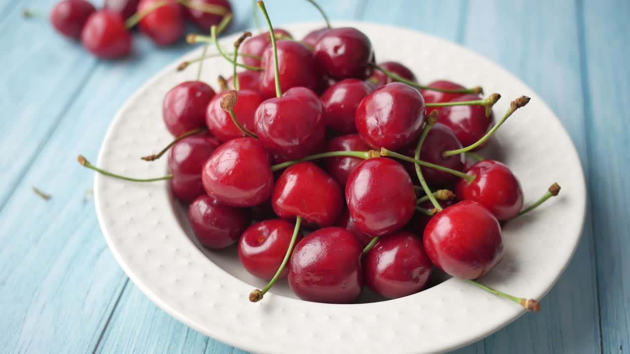 Ciliegie rosse fresche su un piatto bianco