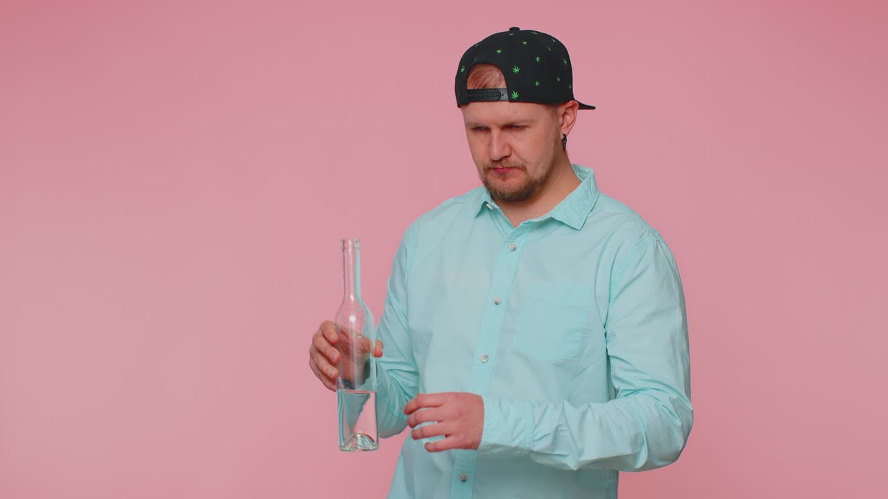 Drunk man after party drinks vodka from bottle celebrating victory win alcohol addiction problem