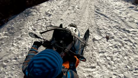 sunny winter landscape with a man traveling finnish lapland with snowmobile