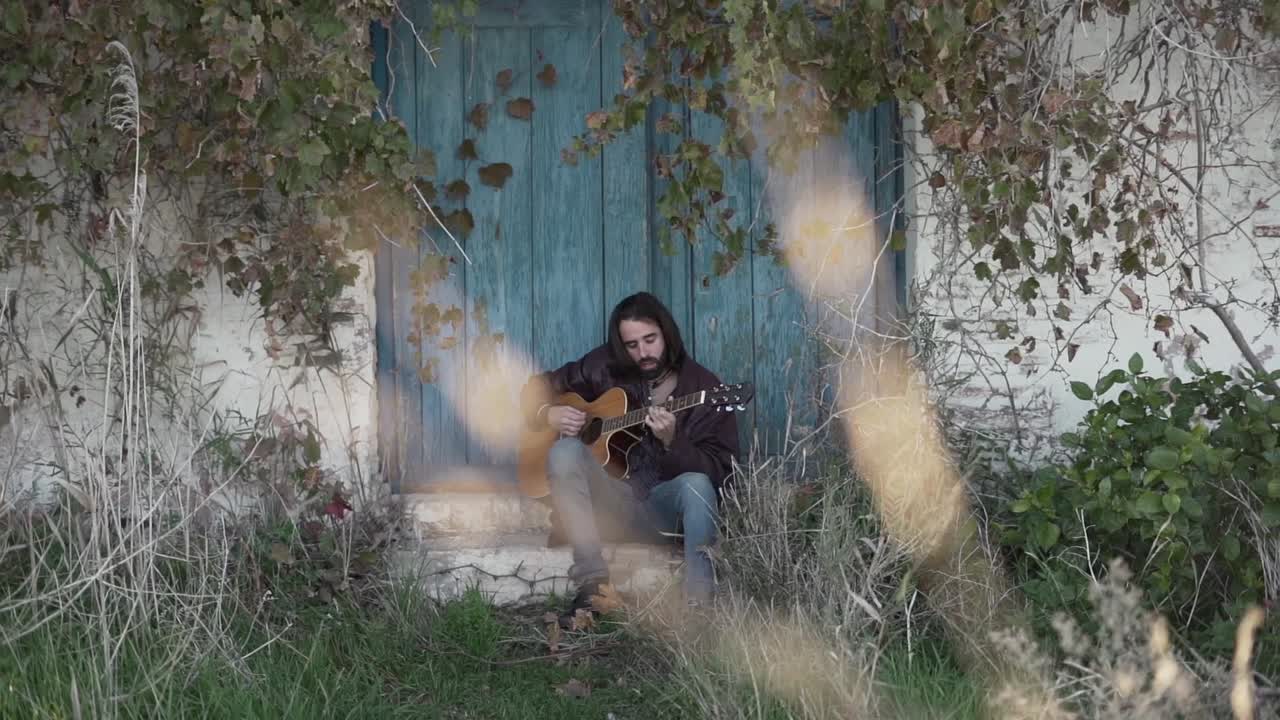 Uomo che suona la chitarra acustica all'aperto
