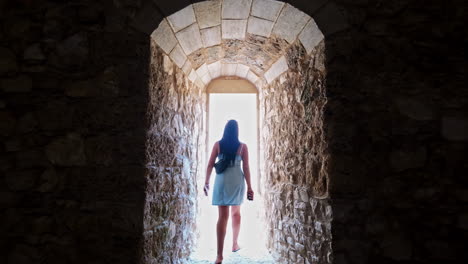 young, attractive woman walking in a castle hallway