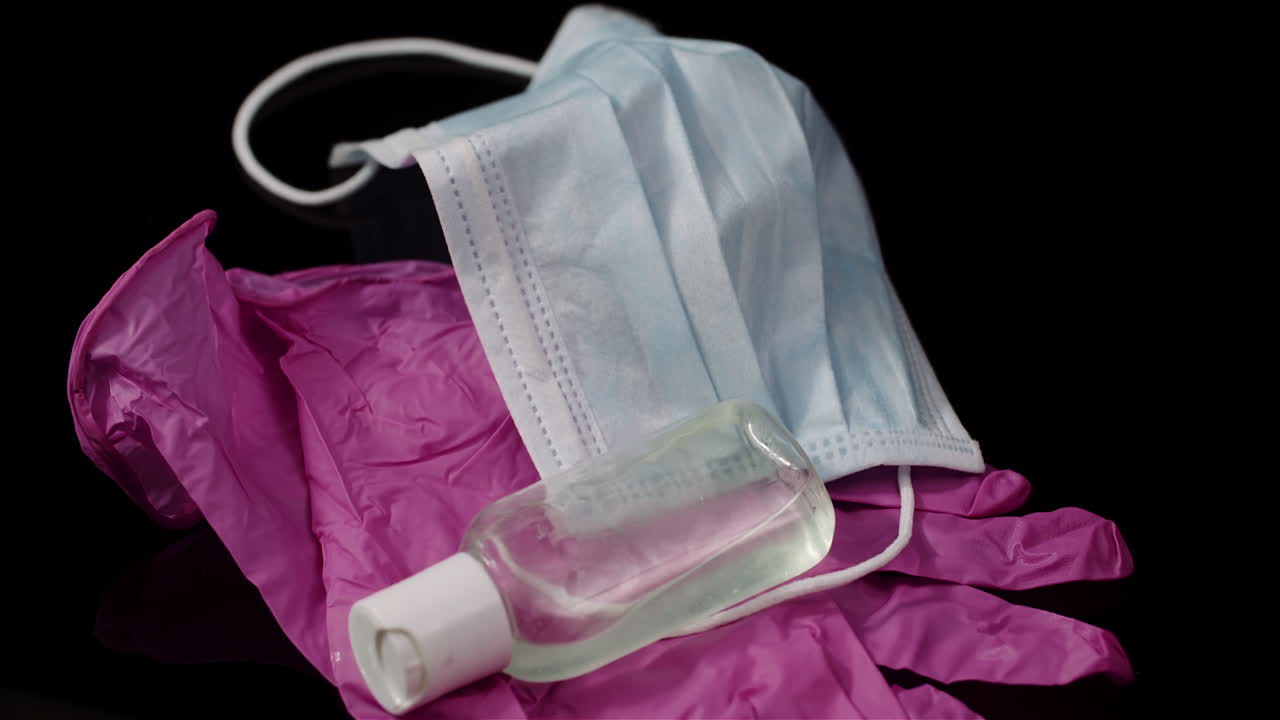 máscara protectora púrpura aislada sobre fondo negro máscara médica giratoria guantes protectores