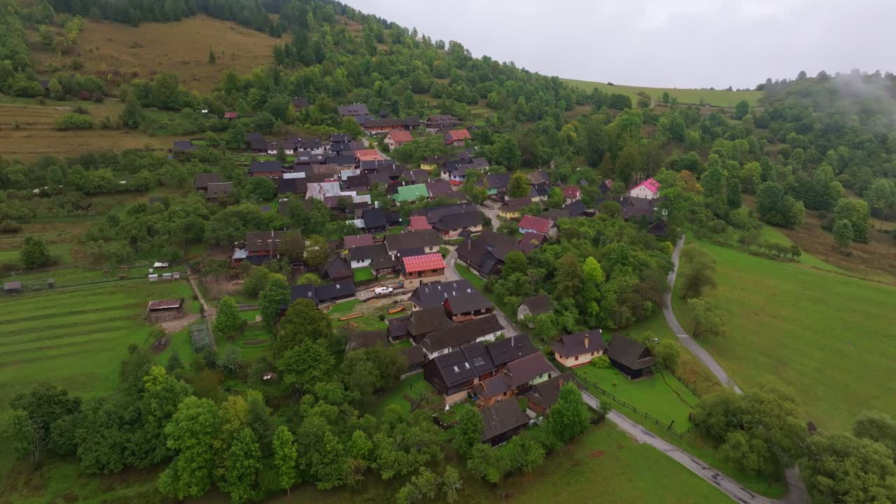 Drone shot of Vlkolinec village glowing under golden sunrise light