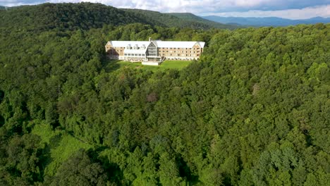 large estate building in appalachian mountain forests in georgia, aerial approach