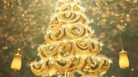 a golden christmas tree with lights and ornaments