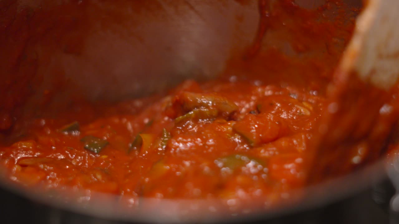 Italian Bolognese Sauce Being Stirred in Slow Motion with Fresh Tomatoes and Vegetables including Courgette, Carrots, Onions, Peppers, Mushrooms. Healthy Mediterranean Diet Food Cooking 4K.