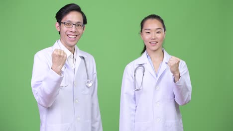 young asian couple doctors with fist raised together