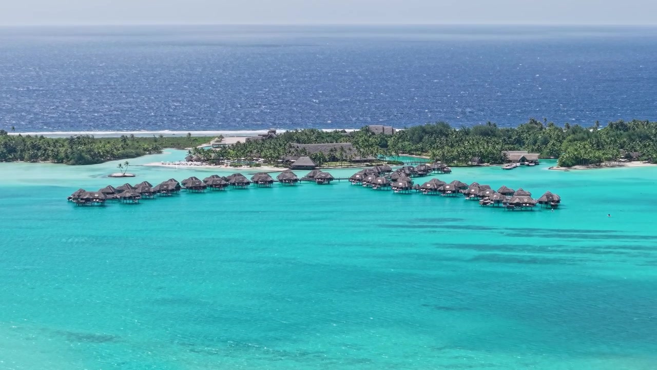 Bora Bora, French Polynesia. Revealing Drone Shot of Luxury Resort Bungalows Over Turquoise Lagoon Water