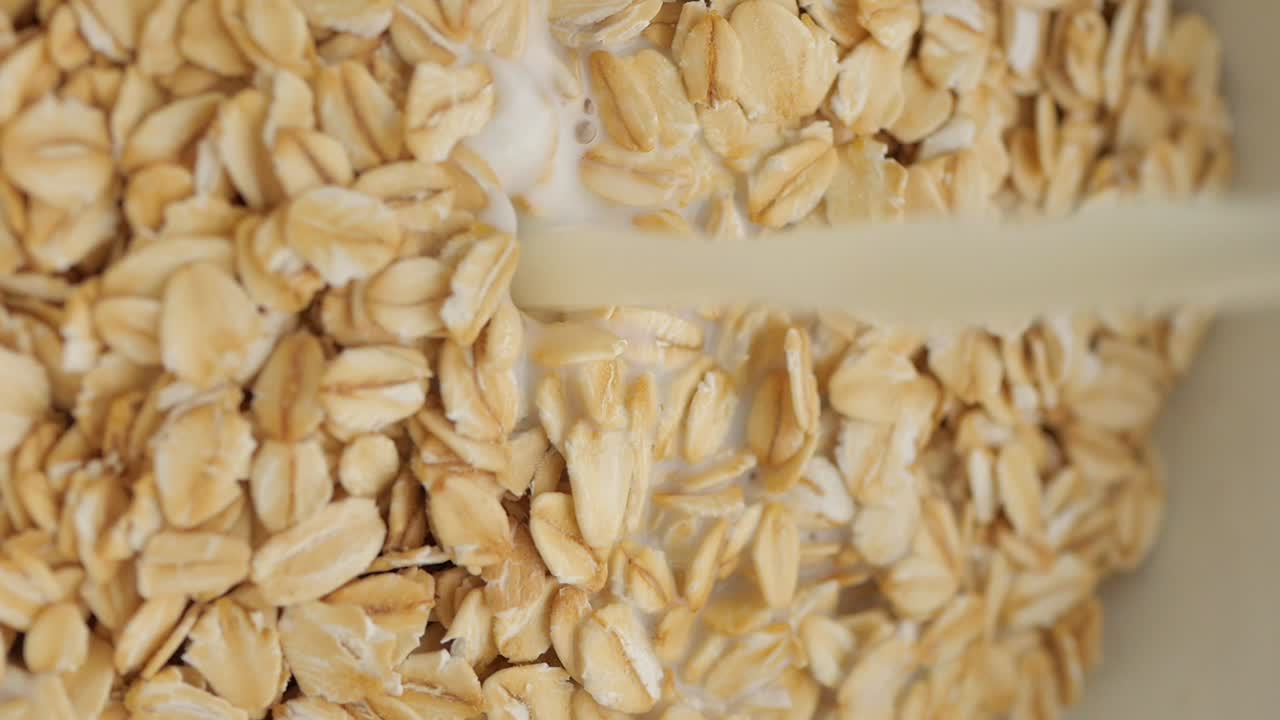 Pouring Milk onto Oats for Breakfast