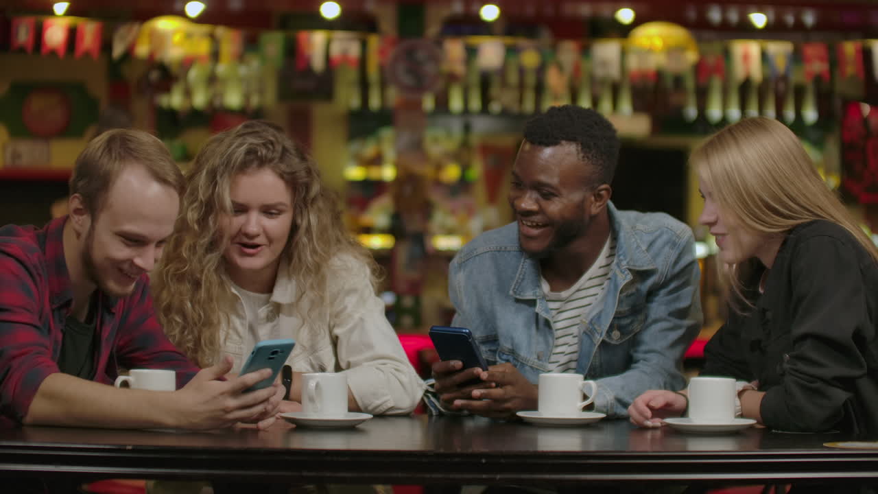 Happy multiracial young people friends talking laughing at group meeting sharing cafe table diverse students drinking coffee having fun together enjoy multi-ethnic friendship pleasant conversation