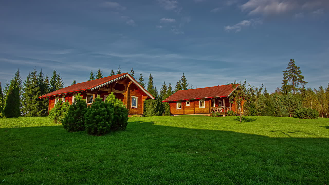 낮에 마을의 아름다운 목조 오두막 위로 떠다니는 구름 위로 정적 샷