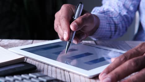 person using tablet with graphs