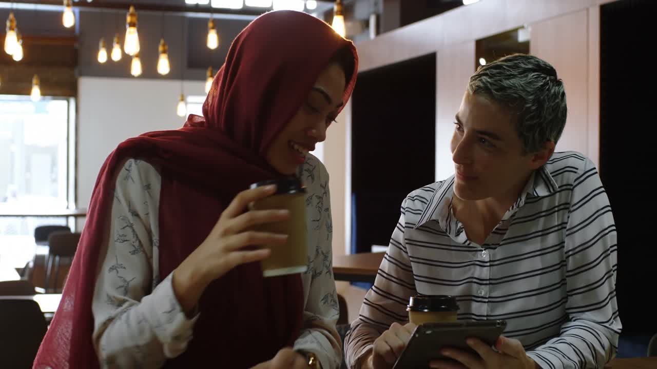 mujeres usando tableta digital en el café 4k