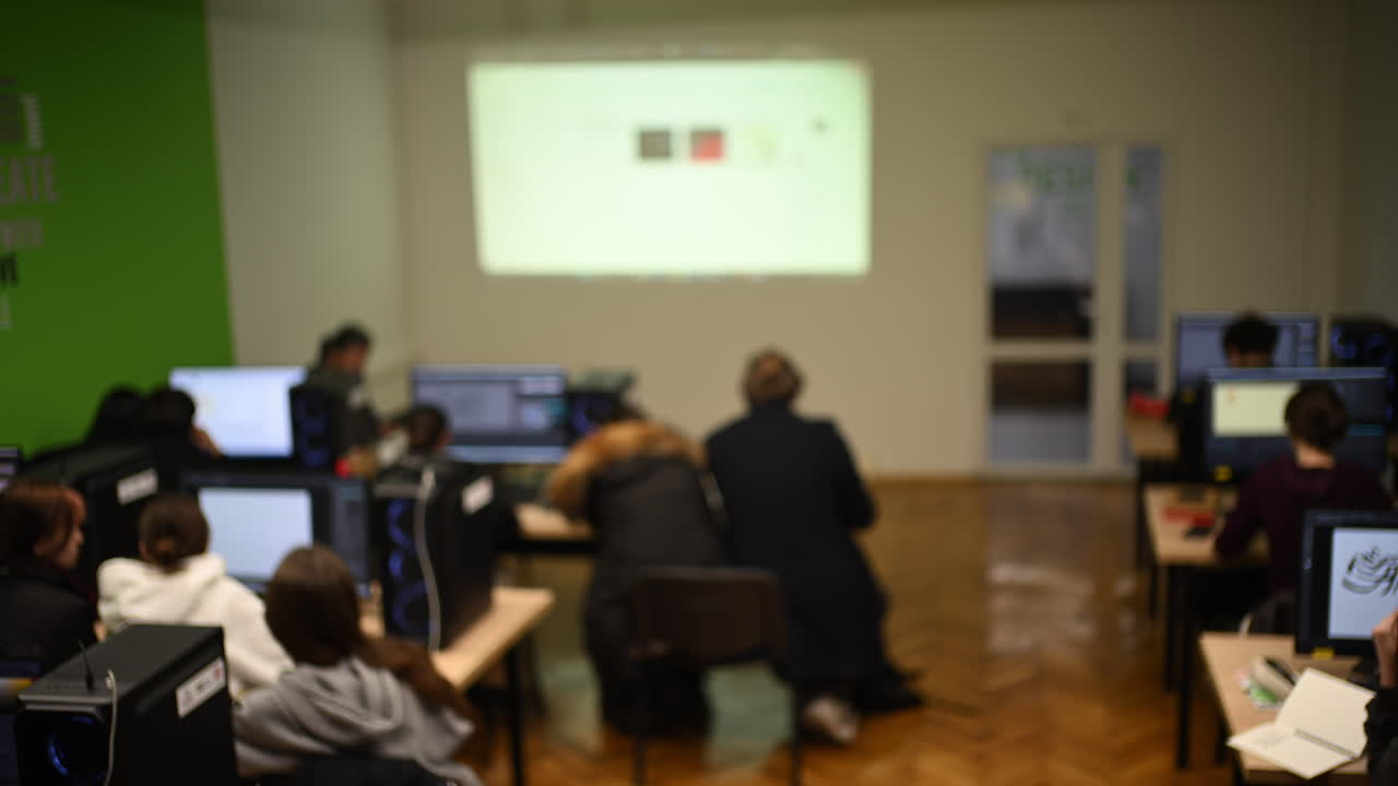 Studenti al computer in classe sotto la guida dell'insegnante.