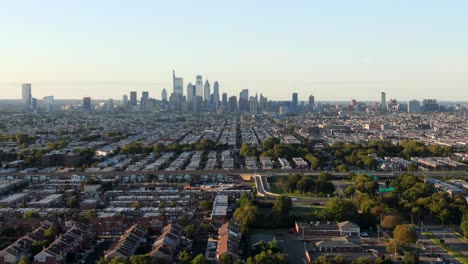 aerial dolly forward shot toward philadelphia skyline urbanscape on horizon during summer dusk