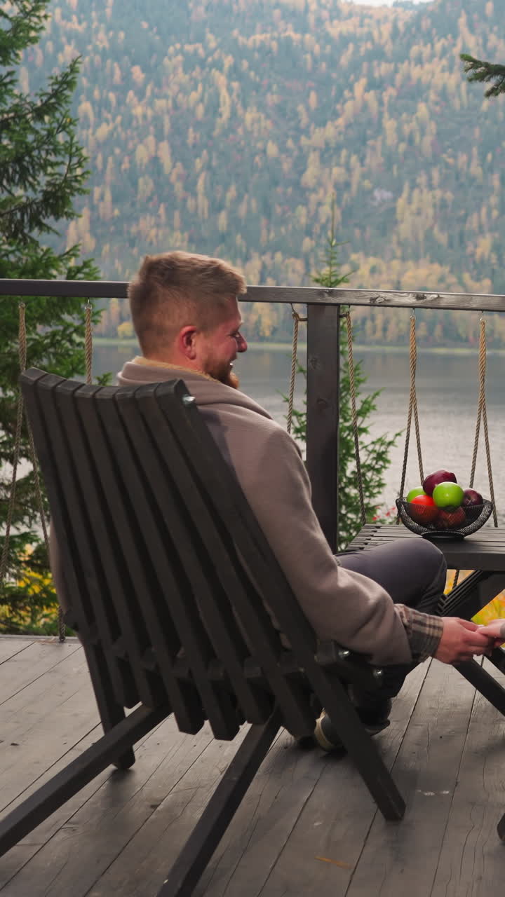 Couple smiles with hands entwined on glamping terrace. Resort offers ideal setting for romantic escape. Picturesque location for time-spending with family