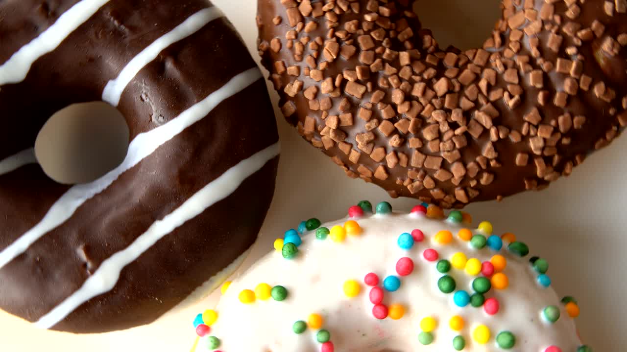 tres deliciosas rosquillas dulces girando en un plato blanco.