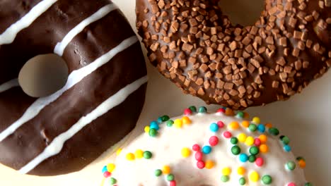 tres deliciosas rosquillas dulces girando en un plato blanco.