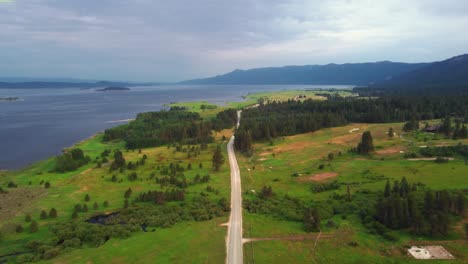 road along the green meadow overlooking the calm blue sea in summer