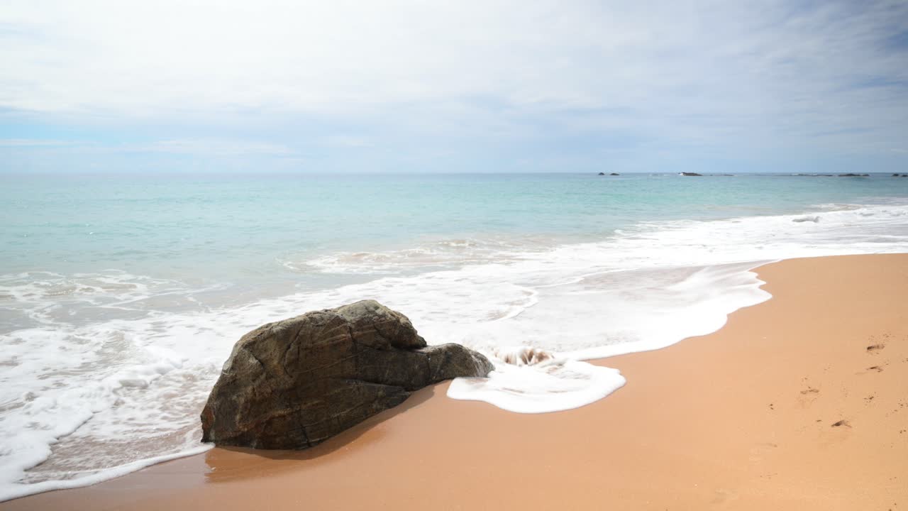 Close up of ocean water and waves. Large rock.