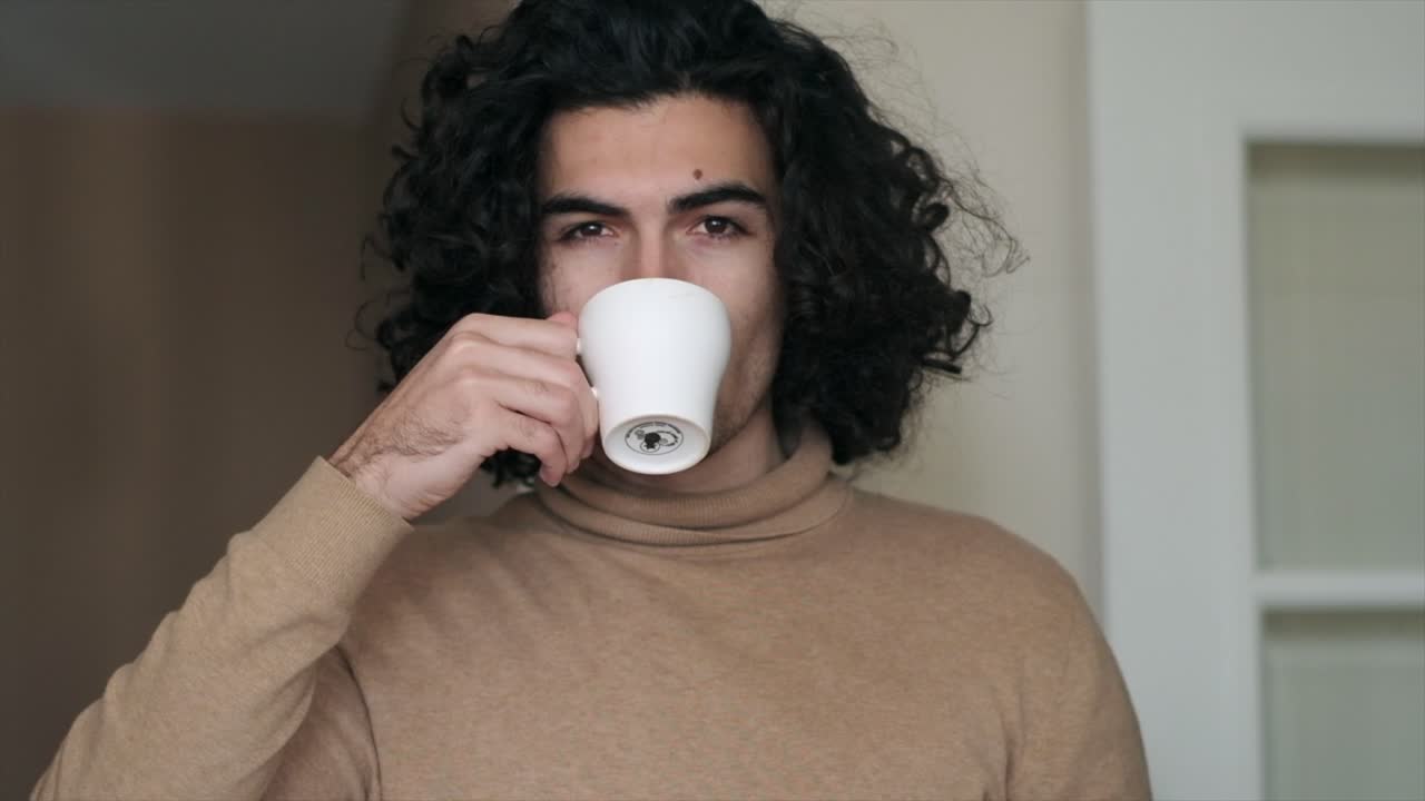 cámara lenta de un hombre caucásico sexy tomando café y mirando a la cámara