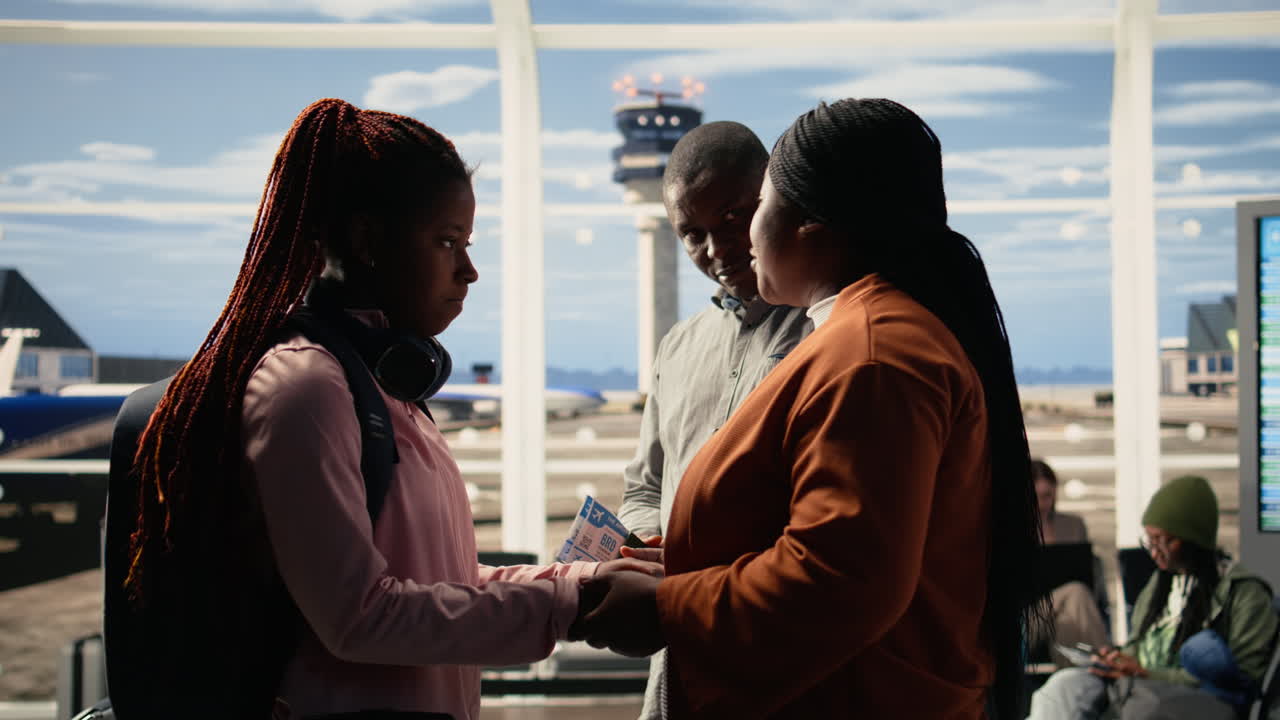 Supportive parents and teenage child in sad goodbye at the airport terminal