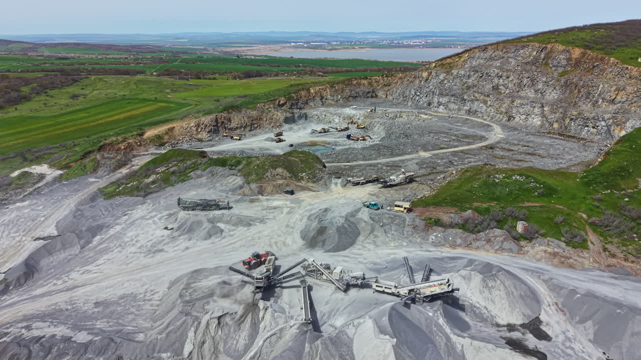 Granite quarry in operation with machinery and workers at site during daylight in open area