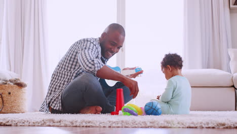 Joven-Padre-Negro-Jugando-Con-Su-Hijo-En-Su-Sala-De-Estar