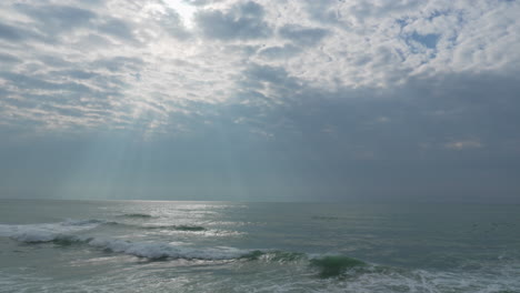 silver light as it reflects on waves in wild sea during dramatic morning