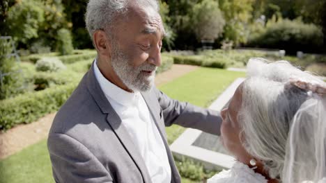 Feliz-Pareja-Birracial-Mayor-Caminando,-Bailando-En-Una-Boda-En-El-Jardín,-Cámara-Lenta