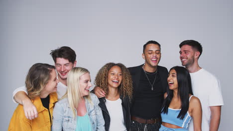 group studio shot of young multi-cultural friends smiling and laughing at camera in slow motion