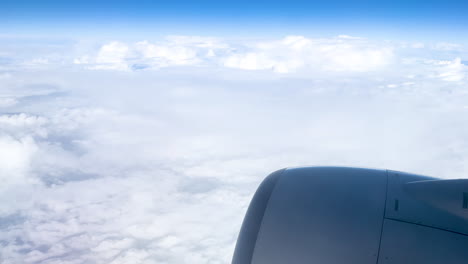 view from airplane window of the wing soaring above the clouds