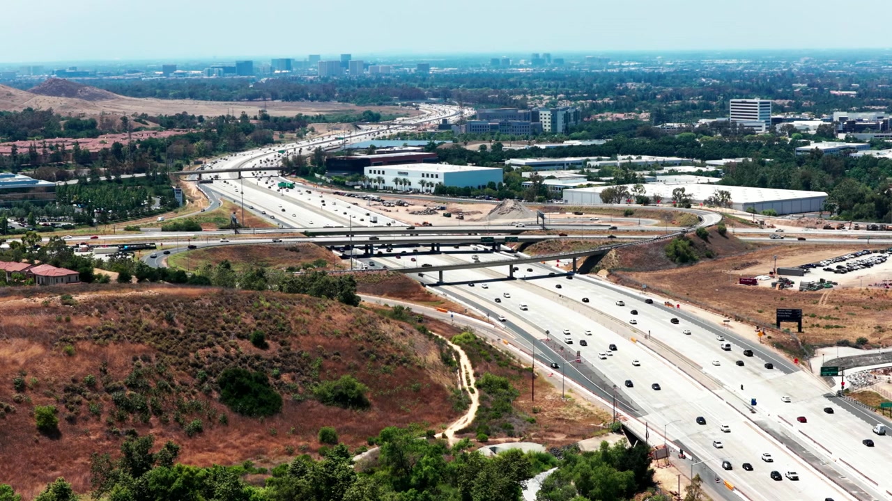 Aerial view of 405 freeway traffic and overpass in Irvine California captured with smooth cinematic drone footage