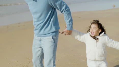 japanese man and his cute little daughter having fun at seashore