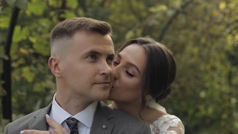 lovely newlyweds caucasian bride embracing groom in park making kiss, wedding couple family hugging