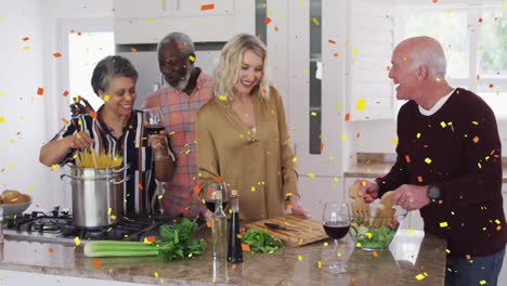 Colorful-confetti-falling-against-two-senior-diverse-couple-cooking-together-in-the-kitchen-at-home