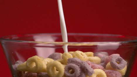 milk being poured over colorful cereal