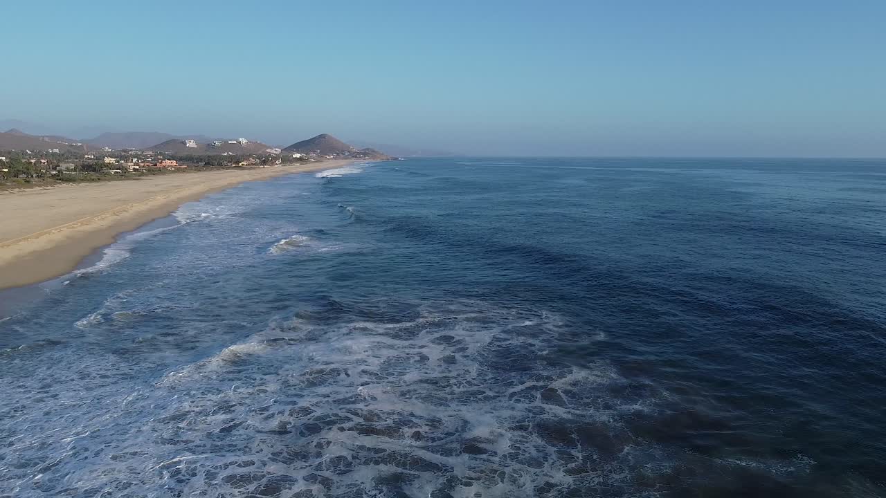 las olas del océano pacífico rompiendo contra la costa con una larga playa de arena blanca en méxico