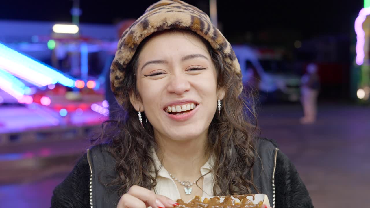 Woman enjoying street food at a night fair
