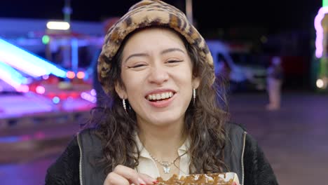 woman enjoying street food at a night fair