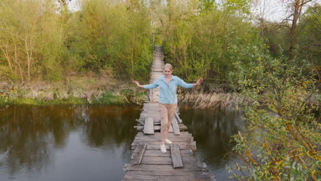 woman walking on a wooden bridge over a river in springtime forest