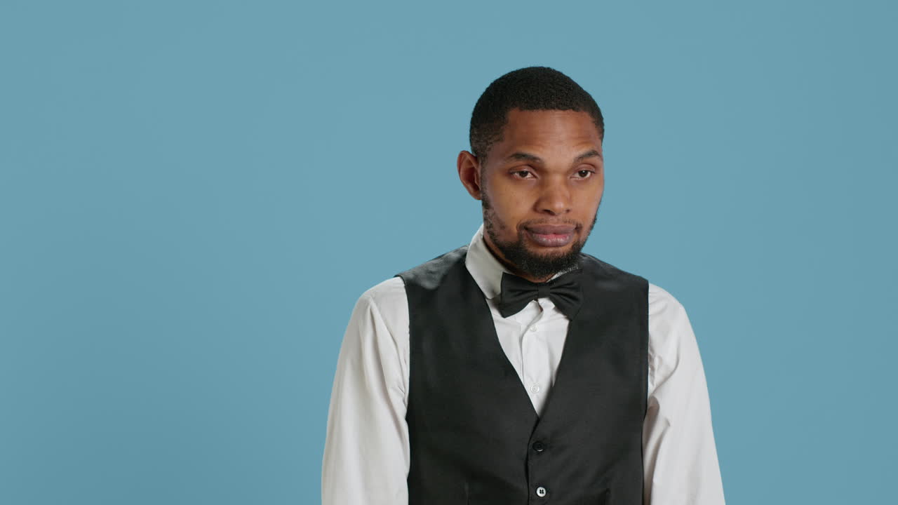 Portrait of bellhop hotel employee posing with arms crossed